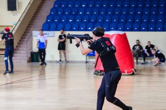 Игрок LASERWAR с автоматом нацелился на противника.